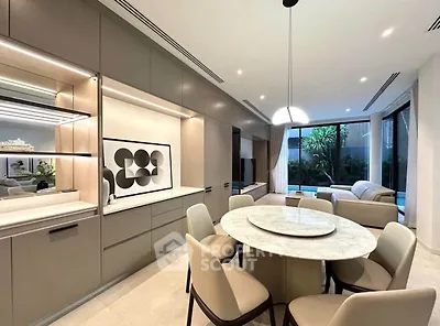 Luxurious open-plan living and dining area with modern decor and pool view.