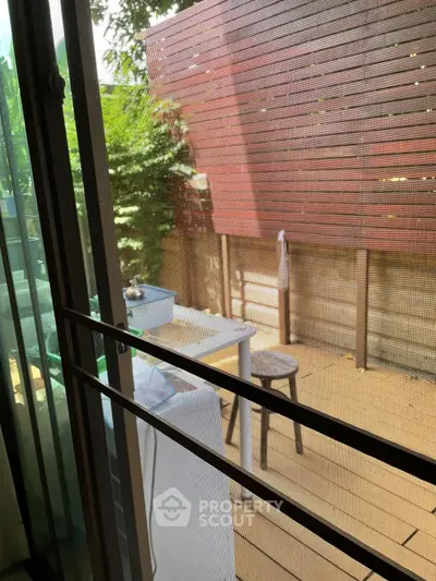 Charming patio view with wooden privacy screen and lush greenery