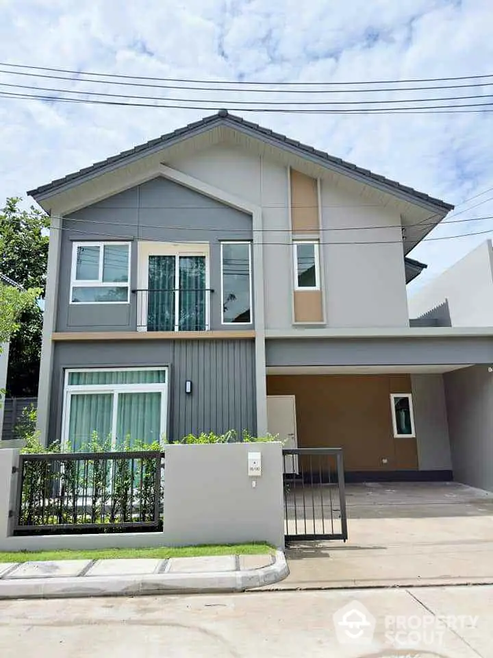 Modern two-story house with stylish facade and gated entrance in a serene neighborhood.