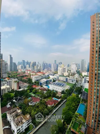 Stunning cityscape view from high-rise building overlooking urban skyline and lush greenery.