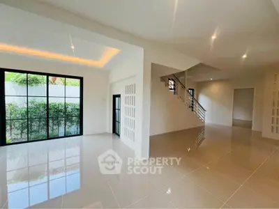 Spacious modern living room with large windows and sleek tile flooring