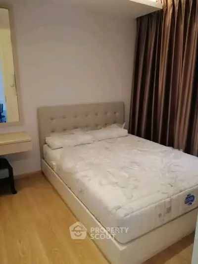 Cozy bedroom with plush bed and elegant curtains in modern apartment