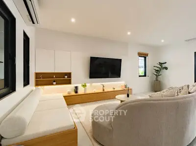Modern living room with stylish furniture and large TV, perfect for relaxation and entertainment.