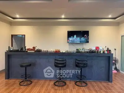 Stylish home bar with modern stools and sleek countertop in a cozy setting.