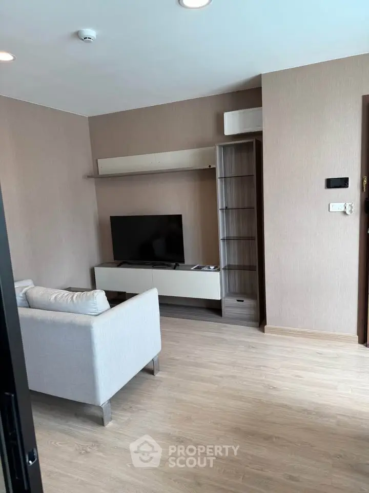 Modern living room with sleek furniture and mounted TV in a stylish apartment.