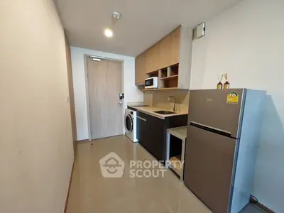 Modern kitchen with sleek appliances and ample storage in a stylish apartment.