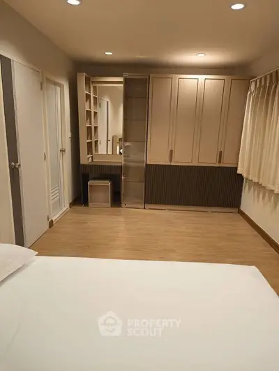 Spacious bedroom with elegant built-in wardrobe and cozy lighting