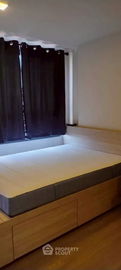 Cozy bedroom with modern wooden bed frame and dark curtains