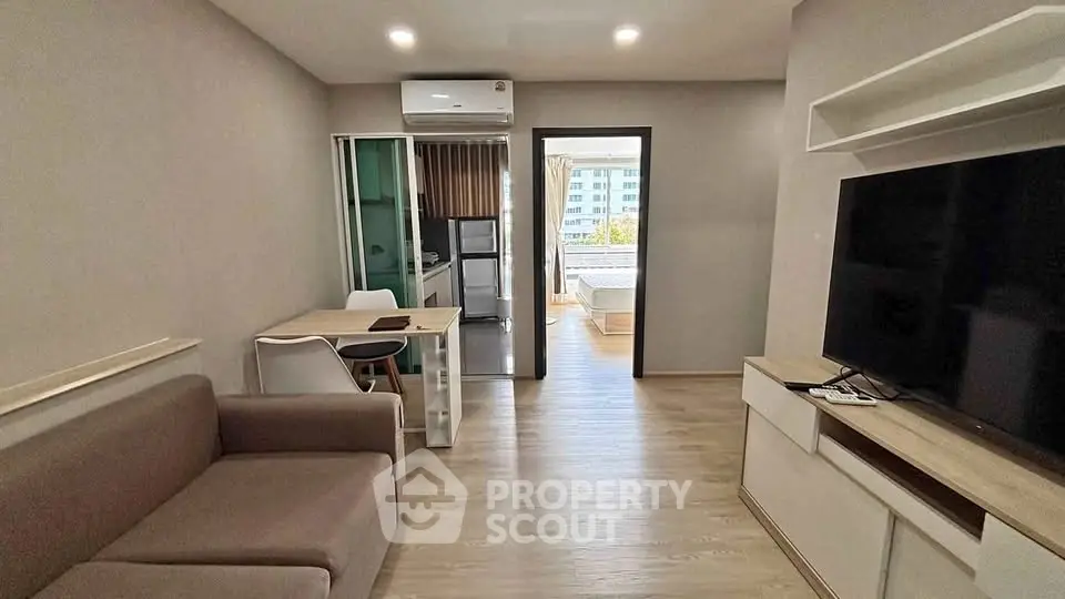 Modern living room with sleek furniture and open kitchen layout in a stylish apartment.