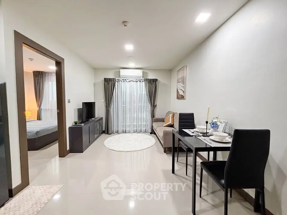 Modern living room with dining area and view into cozy bedroom
