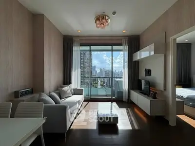 Modern living room with city view, stylish furniture, and large windows in a high-rise apartment.