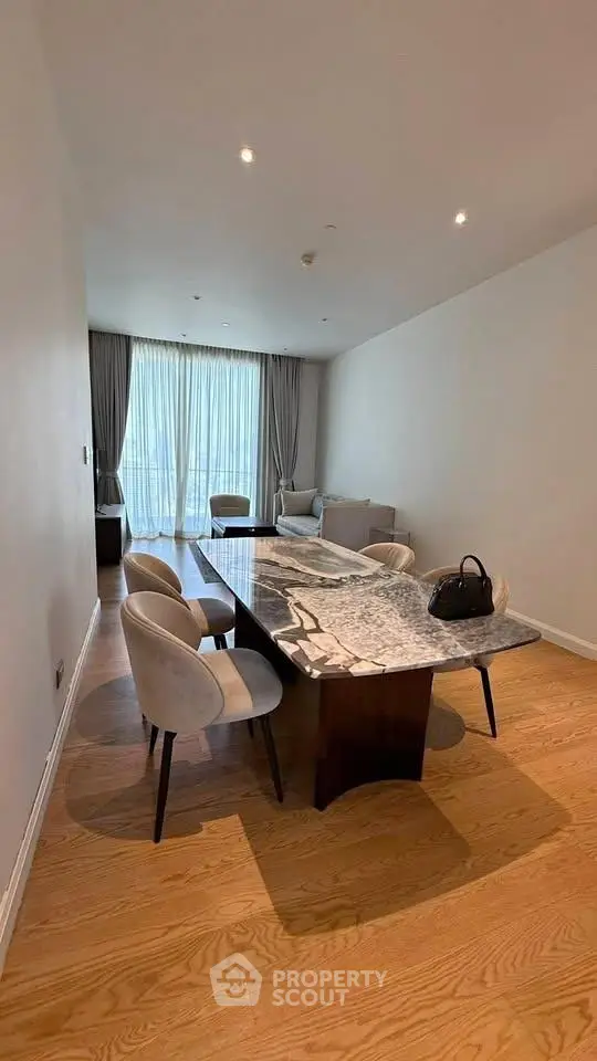 Elegant dining area with marble table and plush chairs in a modern apartment.