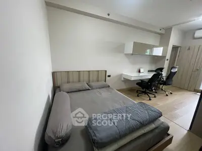 Modern bedroom with sleek furniture and workspace, ideal for urban living.
