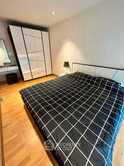 Modern bedroom with stylish wardrobe and checkered bedding