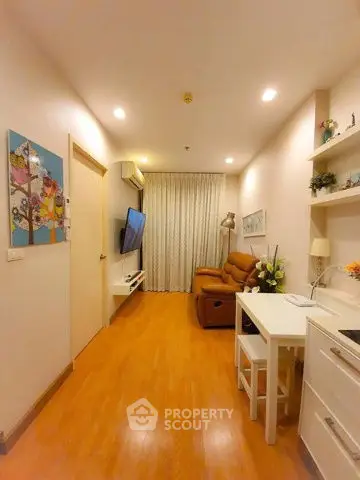 Cozy living room with modern decor and warm lighting, featuring a comfortable sofa and wall-mounted TV.
