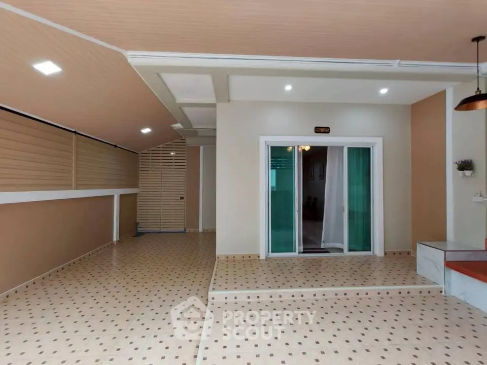 Spacious modern entrance with stylish tiled flooring and sliding glass doors.