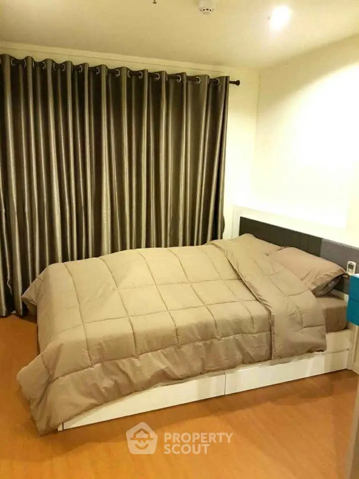 Cozy bedroom with elegant curtains and modern bedding in a stylish apartment.