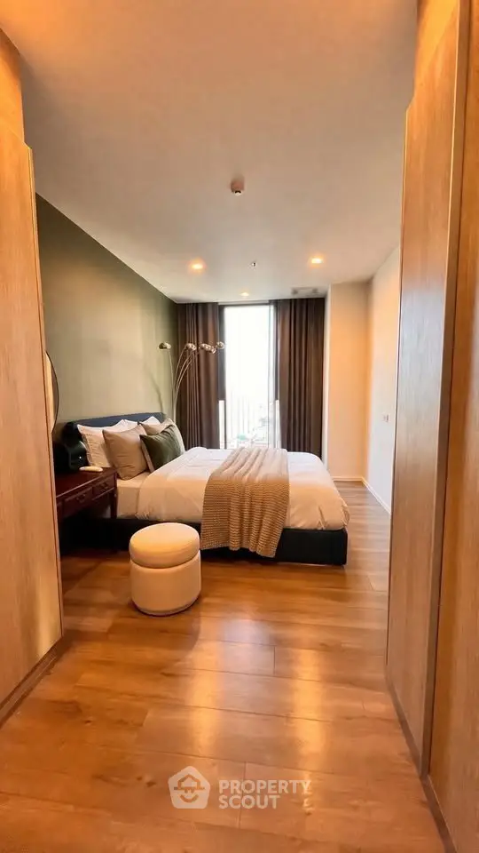 Luxurious bedroom with modern decor and large window offering natural light.