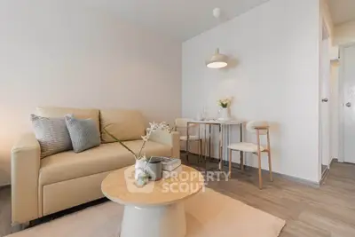 Modern living room with cozy beige sofa and stylish dining area in open layout apartment.