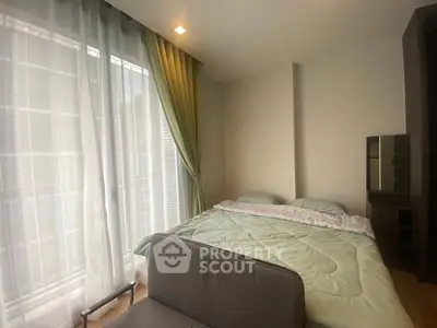 Cozy bedroom with large window and modern furnishings, perfect for relaxation.