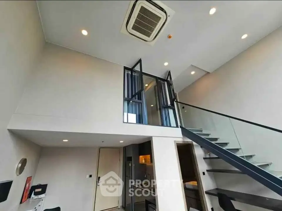 Modern loft apartment with high ceilings and sleek staircase