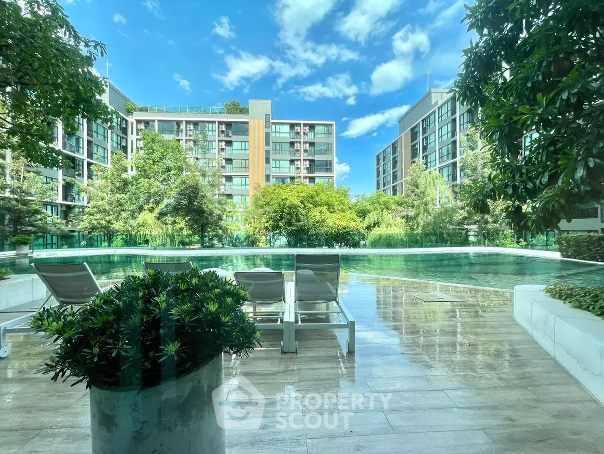 Luxurious poolside view with modern apartment buildings and lush greenery, perfect for relaxation and leisure.