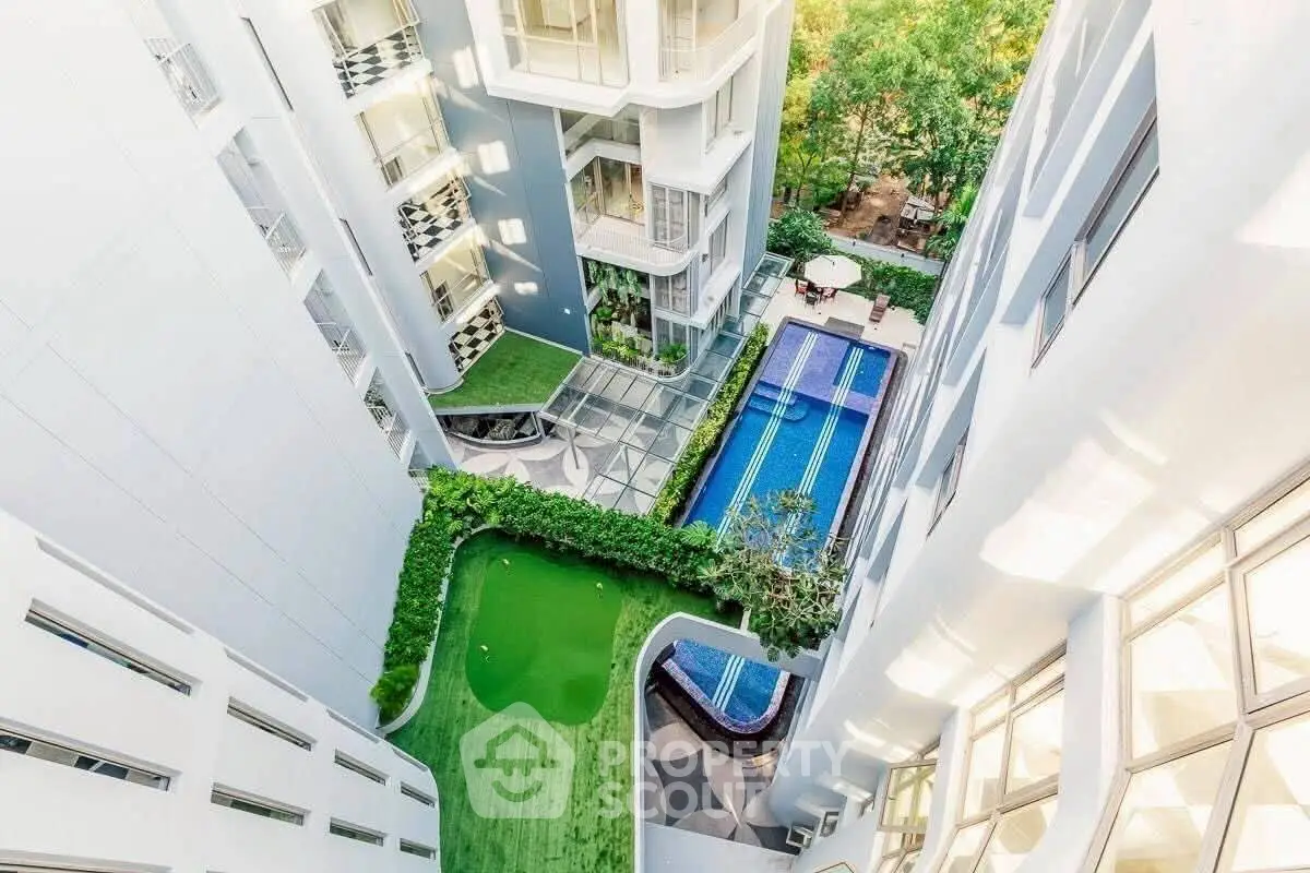Luxurious high-rise building with pool and garden view from above