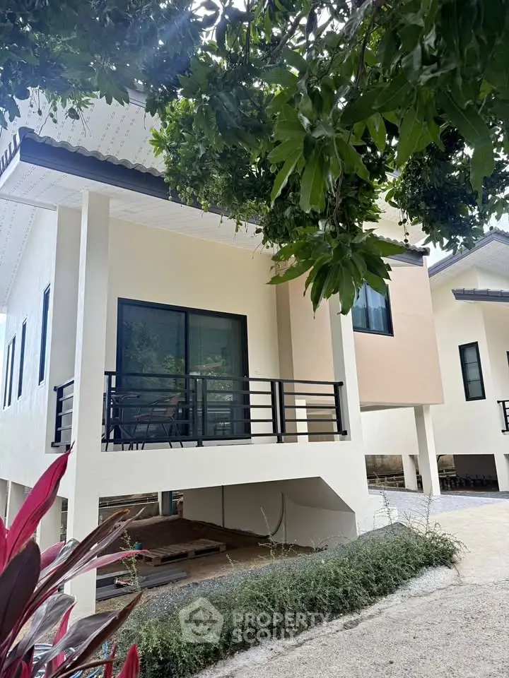 Charming elevated house with modern design and lush greenery surroundings.