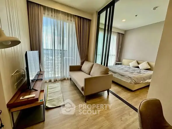 Modern studio apartment with cozy living area and bedroom, featuring floor-to-ceiling windows and stylish decor.