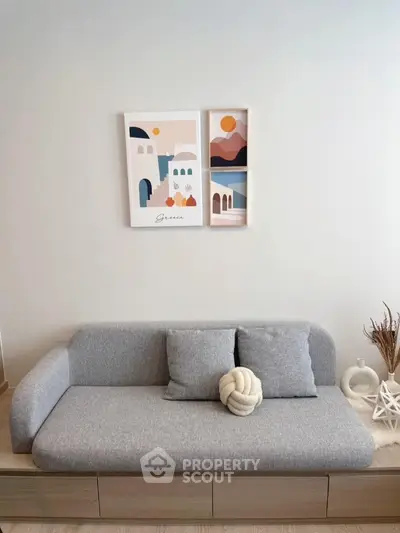 Modern living room with stylish gray sofa and artistic wall decor
