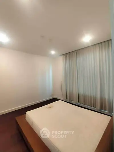 Spacious bedroom with modern design and large windows for natural light.