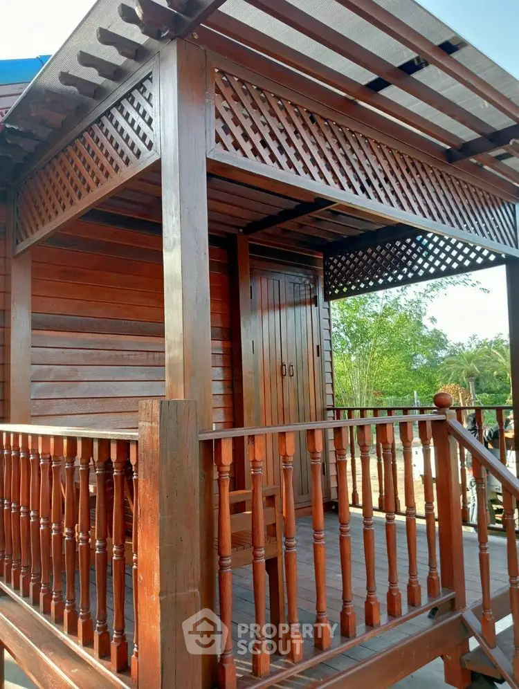 Charming wooden balcony with intricate railing and lattice design, perfect for relaxation.