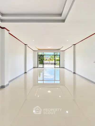 Spacious modern living room with glossy floors and large windows offering stunning views.