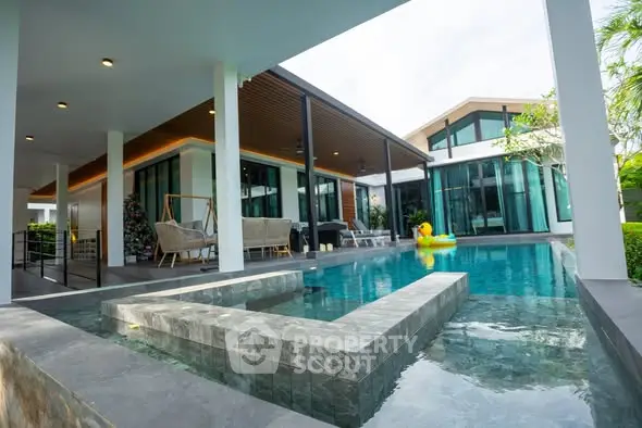 Luxurious modern home with stunning pool and outdoor seating area.
