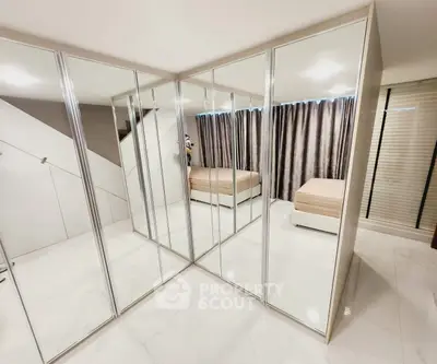 Spacious bedroom with mirrored wardrobes and modern decor