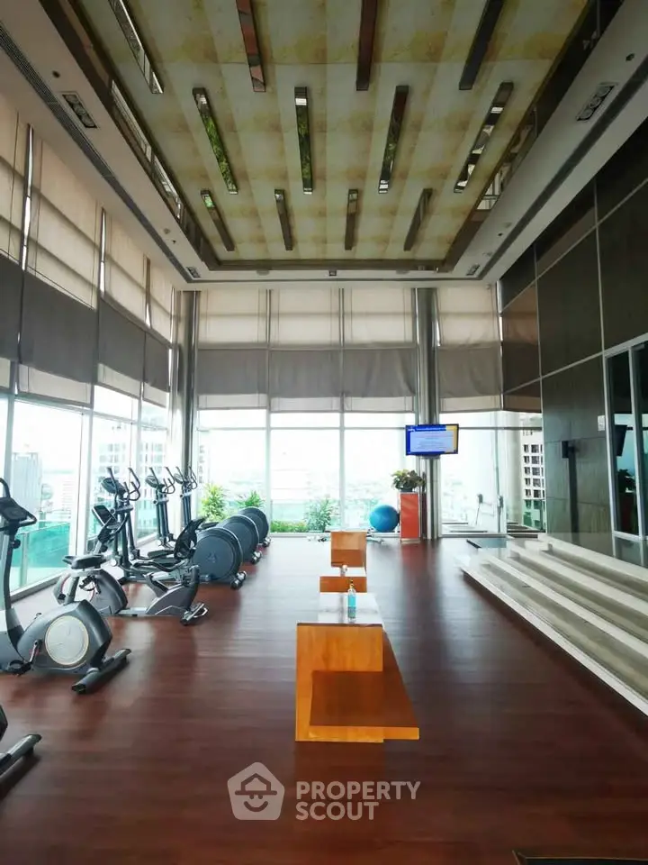 Spacious modern gym with city view and exercise equipment