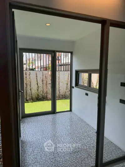 Bright and airy room with large windows and modern tile flooring, perfect for versatile use.