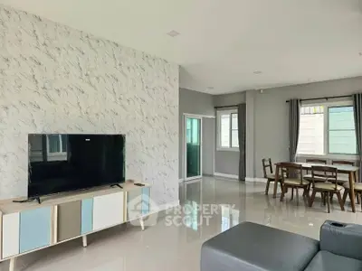Modern living room with stylish TV stand and dining area, featuring elegant decor and natural light.