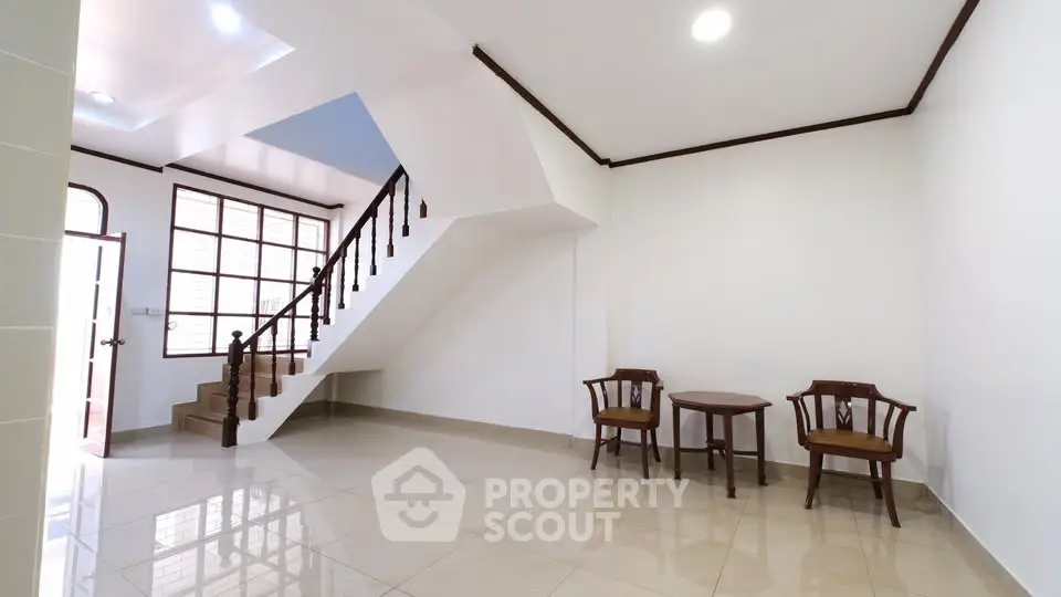 Spacious interior with elegant staircase and seating area, perfect for modern living.