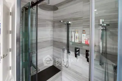 Luxurious modern bathroom with sleek glass shower and elegant tile design.