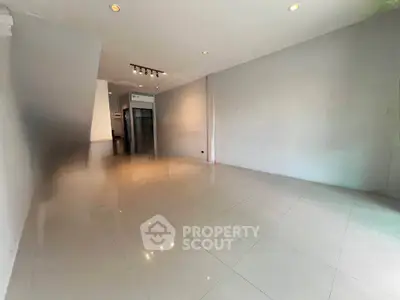 Spacious empty room with modern lighting and glossy tiled floor
