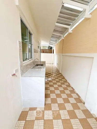 Charming outdoor kitchen with tiled flooring and modern sink setup