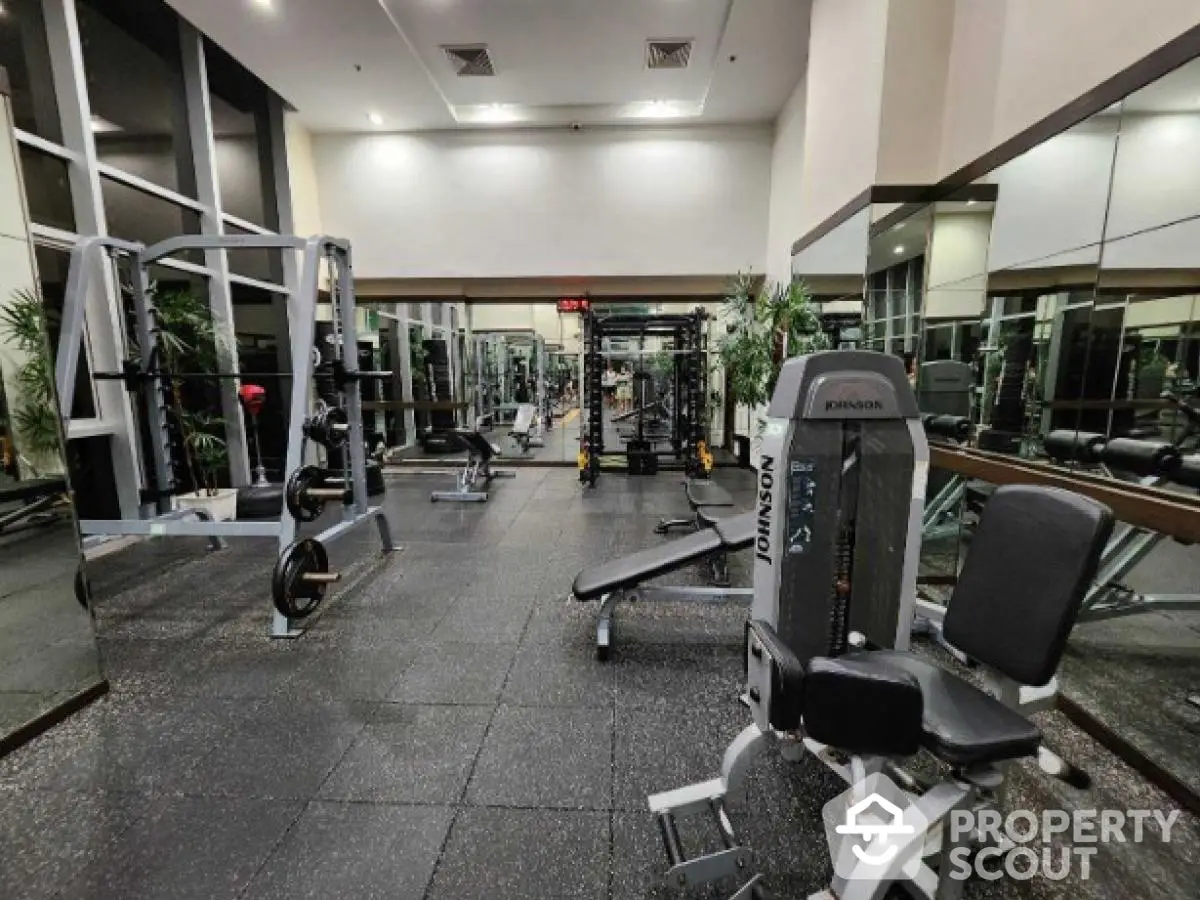 Spacious modern gym with state-of-the-art equipment in luxury residential building.