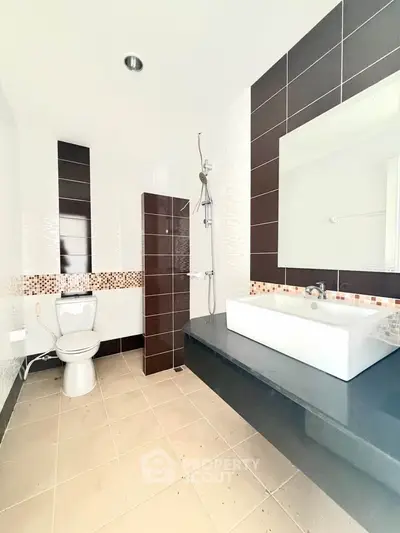 Modern bathroom with sleek design, featuring a large mirror, stylish sink, and contemporary shower area.