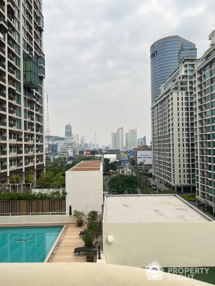 Stunning cityscape view from high-rise building with pool and modern architecture.