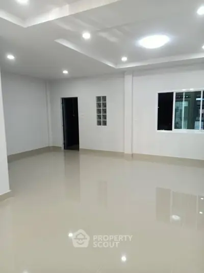 Spacious modern living room with glossy tiled floors and recessed lighting