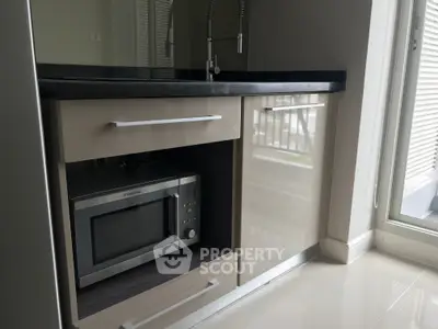 Modern kitchen with sleek cabinetry and built-in microwave