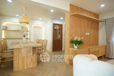 Stylish open-plan living and dining area with modern wooden decor and elegant lighting.