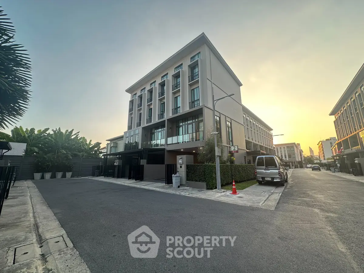 Modern building exterior with sunset view, showcasing contemporary architecture and urban setting.