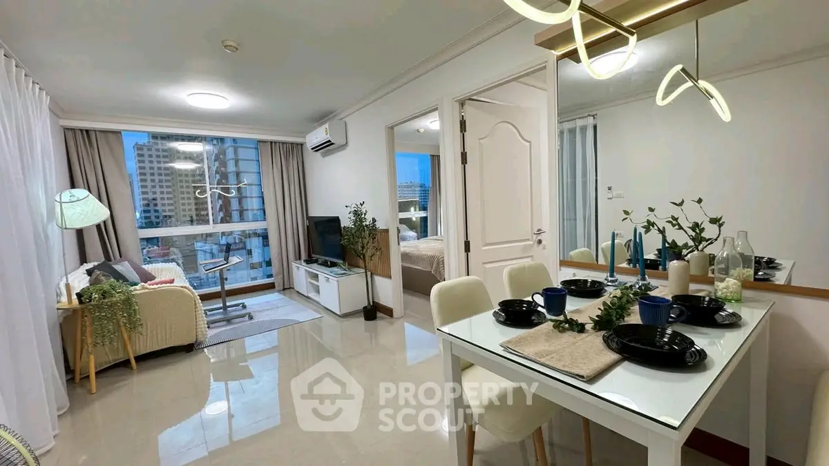 Modern open-plan living and dining area with city view, stylish decor, and natural light.